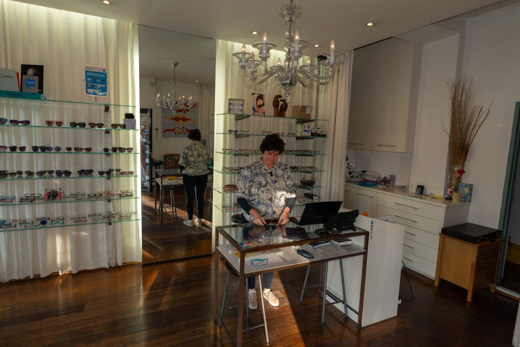 VeyeP Optometry owner arranging designer eyewear inside the Balmain boutique